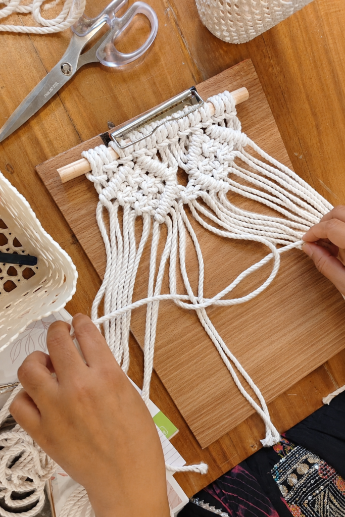 Beginner learning basic macramé knots during a macramé workshop at Crafty Knots Studio Goa
